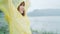 Young Asian woman feeling happy playing rain while wearing raincoat standing near lake. Lifestyle women enjoy and relax in rainy