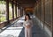 Young Asian woman in the hallway of large ancient Buddhist temple