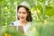 Young asian woman happy and smiling, smart farmers and entrepreneurs in garden, tablet checking quality, recording science