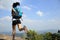 Young asian woman hiker running on mountain peak