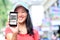 Young asian woman hold smart phone show quick response coupon code