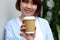 Young asian woman holding a coffee cup with smilling face, hot drink