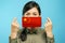 Young asian woman holding a medical protective mask in their hands with the Chinese national flag on a blue background