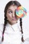 Young Asian woman holding a multicolored lollipop against white background