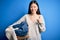 Young asian woman holding wicker laundry basket doing domestic chores happy with big smile doing ok sign, thumb up with fingers,