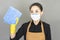 Young Asian Woman housewife in brown apron wore face mask in hands Wipes for washing isolated on gray background,housework and