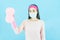 Young Asian Woman housewife in pink gloves wore face mask in hands sponge for washing windows,Wipe clean isolated on blue