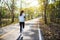 A young asian woman jogging in city park in the morning