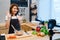 Young asian woman in kitchen recording video on camera. Smiling asian woman working on food blogger concept.