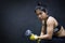 Young Asian woman lifting dumbbell, weight training