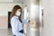 Young asian woman looking watch while waiting elevator