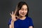 Young asian woman making OK sign over grey background. Winner. Success. Positive korean girl smiles to camera. Body
