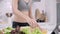 Young Asian woman making salad healthy food while using tablet for looking recipe in the kitchen.