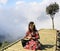 Young Asian woman meditating on the bamboo bridge with clouds on background