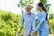 Young Asian woman nurse care giver helping senior old man with mobility walker in garden at home. Senior daycare center, Nurse