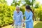 Young Asian woman nurse care giver helping senior old man with mobility walker in garden at home. Senior daycare center, Nurse