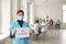 Young asian woman nurse in medical uniform and protective mask standing with sign vaccination