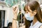 Young Asian woman passenger wearing surgical mask and listening music via mobile phone in subway train