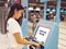 Young Asian woman with passport using self check-in kiosk touch