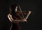 Young asian woman playng the violin on black