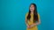Young Asian woman portrait over blue background, smile happy studio shot 4K