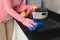 Young asian woman preparing to clean the kitchen. Hand holding d