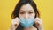 Young asian woman putting on medical mask. Close up. Prevention of the covid-19 spread