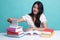 Young Asian woman read a book with books on table