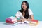 Young Asian woman read a book with books on table