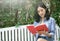 Young Asian woman reading a book relaxing in chair at garden on