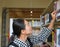 Young asian woman researching on the bookshelf in the library