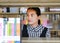 Young asian woman researching on the bookshelf in the library