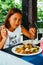 Young Asian woman at the restaurant eating stir fry rice noodle with meat and vegetables, Philippine food call pansit bihon