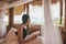 Young asian woman resting and reading a book on the bed in thatched hut among the mountain on vacation