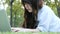 Young asian woman`s legs on the green grass with open laptop. Girl`s hands on keyboard. Distance learning concept.