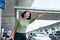 A young Asian woman see her car that her booked via a ride hailing app and are waving it down