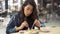 Young Asian woman sitting in cafeteria eating meal. Beautiful Asia girl having dinner alone