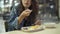 Young Asian woman sitting in cafeteria wearing protective face mask looking at camera. Beautiful Asia girl sitting in