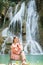 Young Asian woman sitting on a chair In front of the Khoun Moung Keo Waterfall