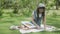 Young asian woman sitting drawing picture with colorful paint brush while leisure in the park.