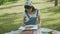 Young asian woman sitting drawing picture with colorful paint brush while leisure in the park on summer.