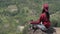 A Young Asian Woman Is Sitting on a Mountain in a Lotus Position, Meditating in Nature with a View of the Forest