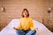 Young asian woman sitting practicing doing yoga meditation in bedroom,Workout exercise after wake up in morning