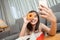 Young asian woman takeaway eating donut junk food enjoy to selfie update on social in living room