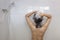 Young asian woman taking a shower and washing hair under warm water falling from rain showerhead in white bathroom