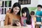Young asian woman teacher teching girl by using tablet, education online, technology lifestyle