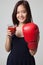 Young Asian woman with tomato juice and boxing glove.