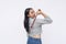 A young asian woman using a backscratcher. Using a convenient toll to scratch her back. Isolated on a white background