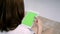 Young asian woman using black tablet device with green screen.