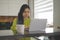 Young asian woman using laptop on her balcony. Home entertainment or distance learning concept